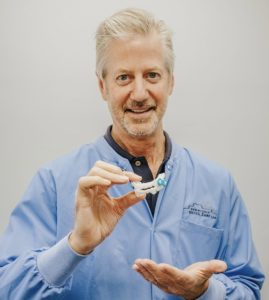Dr. Schumacher holding oral sleep appliance